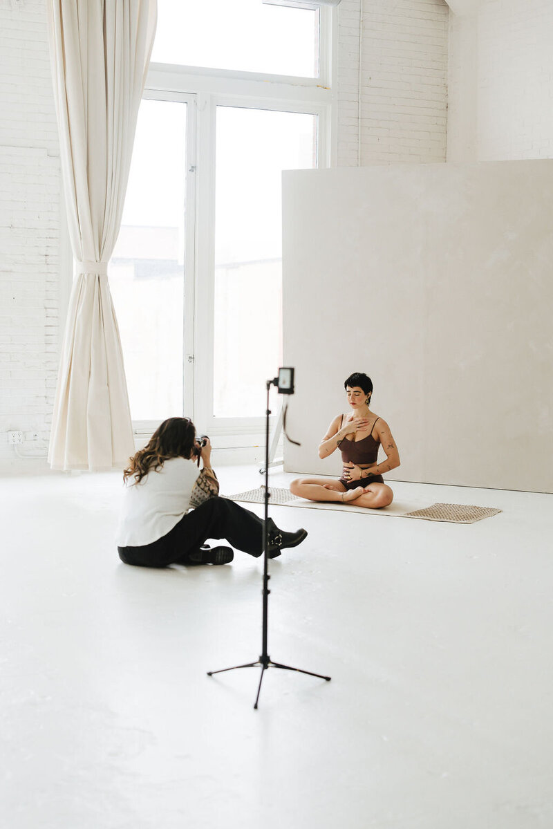 A woman taking video footage of kitten heels in a studio rental in Chicago.