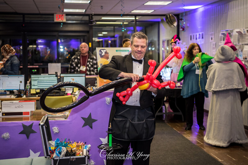 A man making a balloon animal at the Wayne YMCA fundraising event.