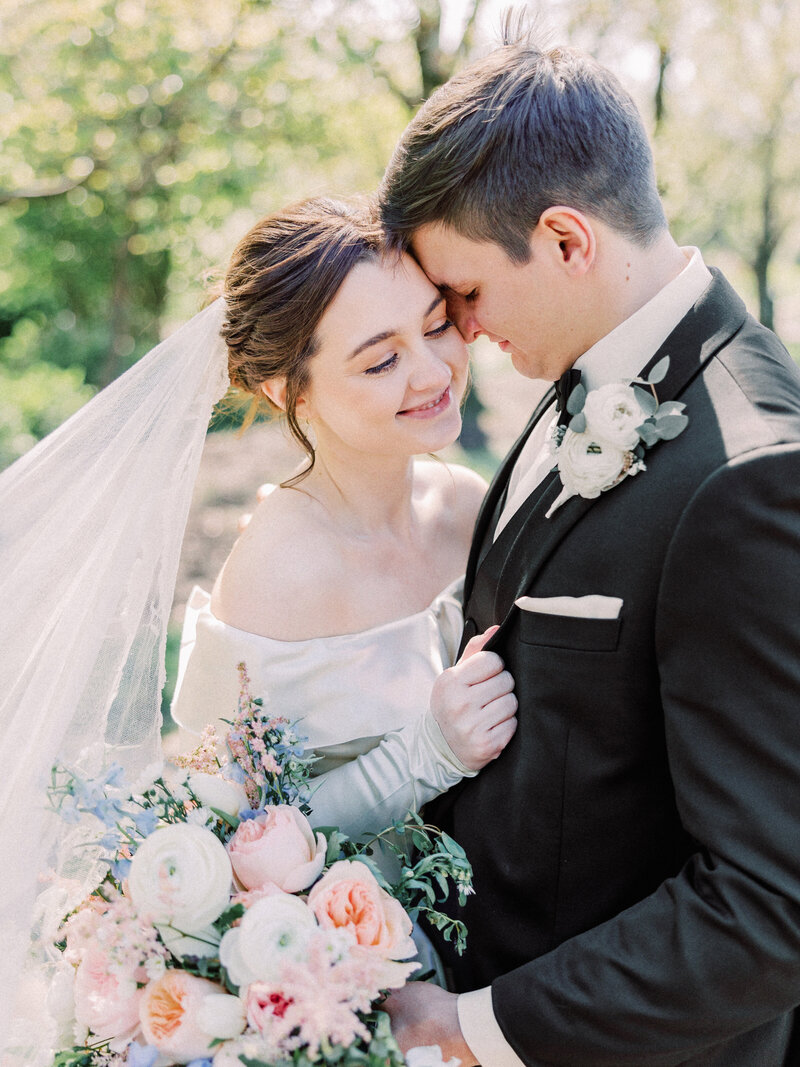 Timeless image of catholic groom nuzzling bride's temple photographed with film