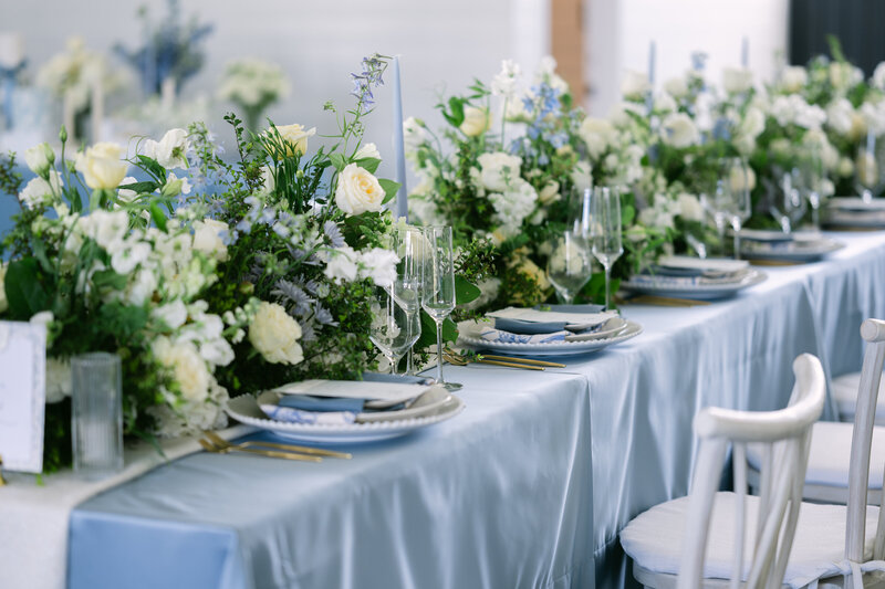 spokane farmhouse wedding venue banquet table set in blue with white flowers