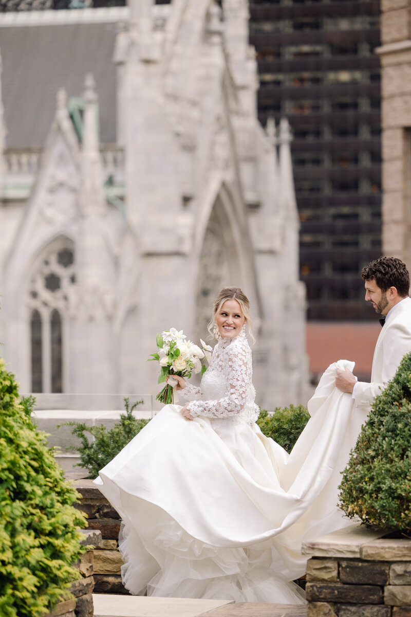 Groom carrying brides dress rooftop photo
