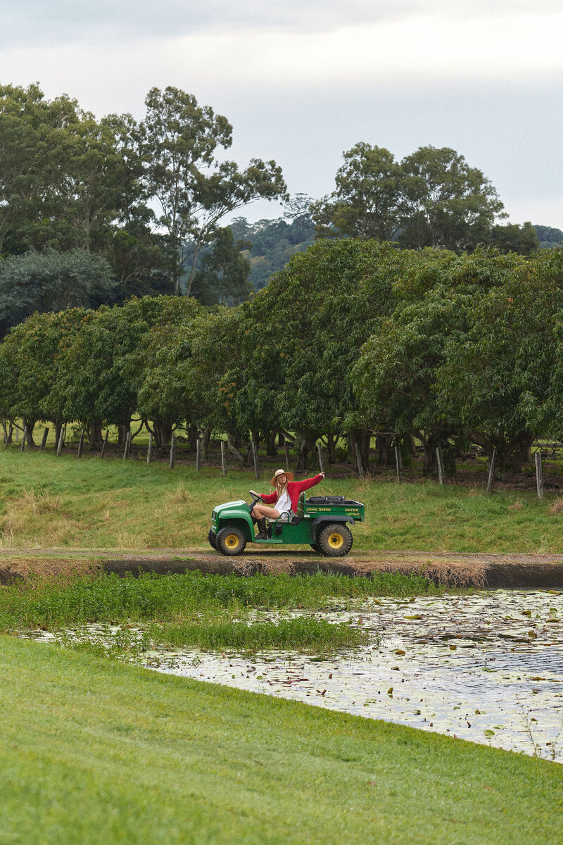 Model driving farm vehicle past dam.
