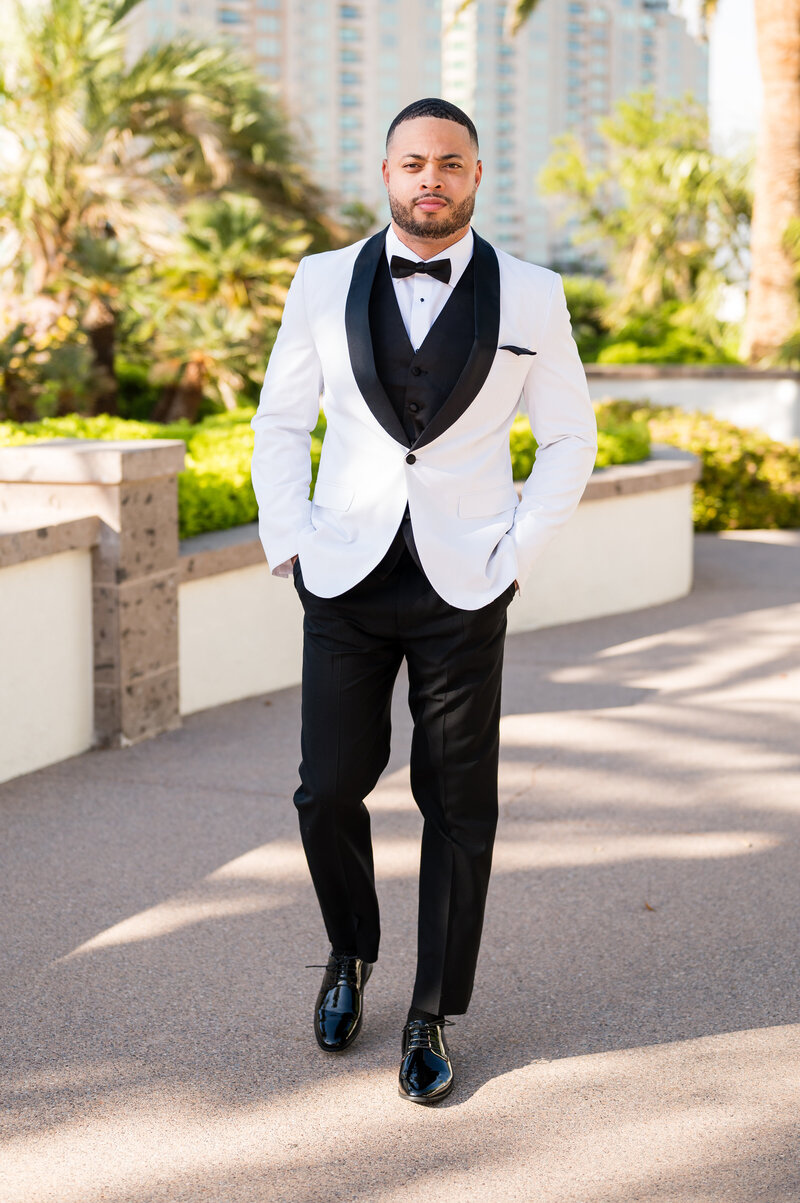 Groom adjusting cufflinks in classic black tuxedo from Men’s Warehouse at Emerald at Queensridge.