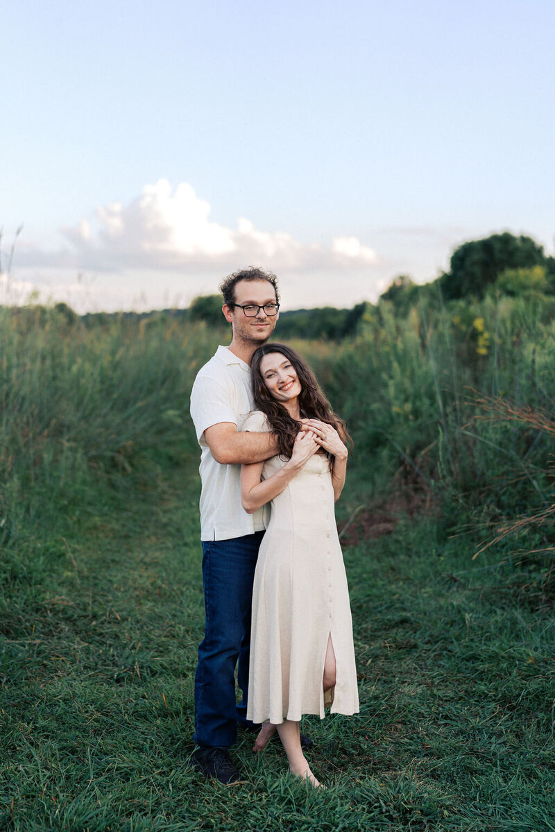man and woman stand in field at seven islands state birding park near knoxville tennessee