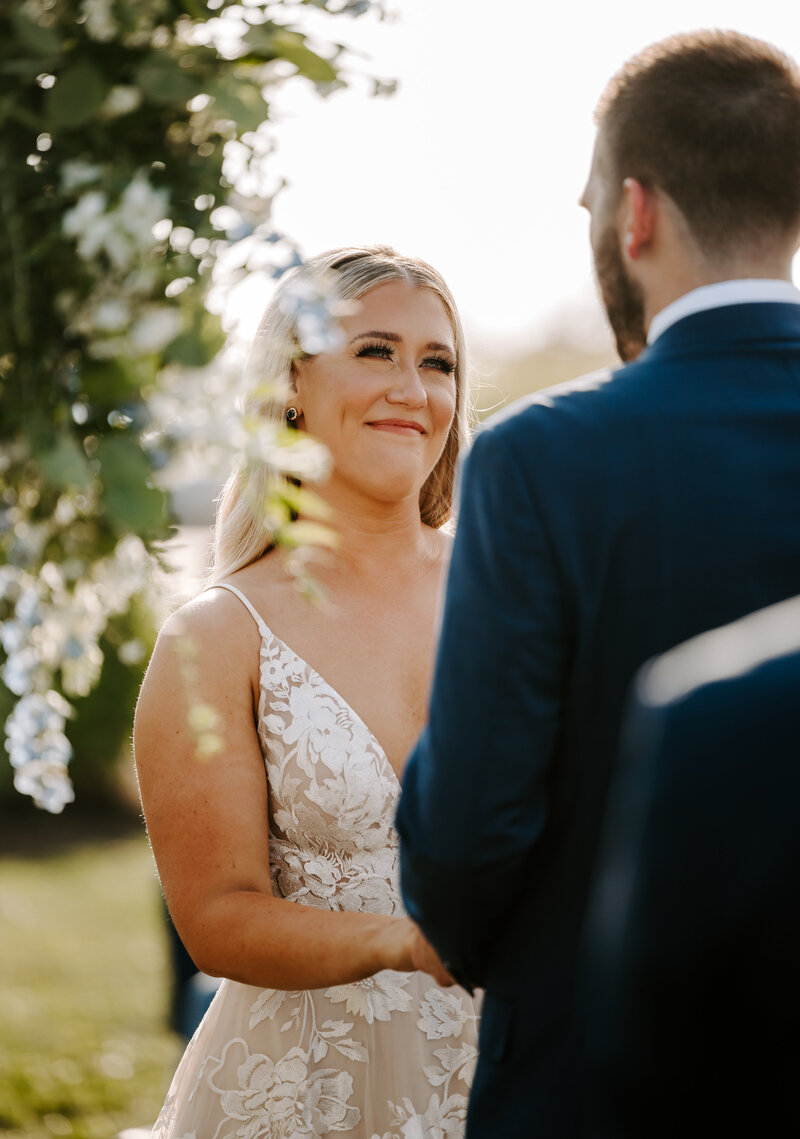 Bride looks lovingly into Groom's eyes while exchanging vows during their summer wedding ceremony at The Wychmere Beach Club in Cape Cod, Massachusetts