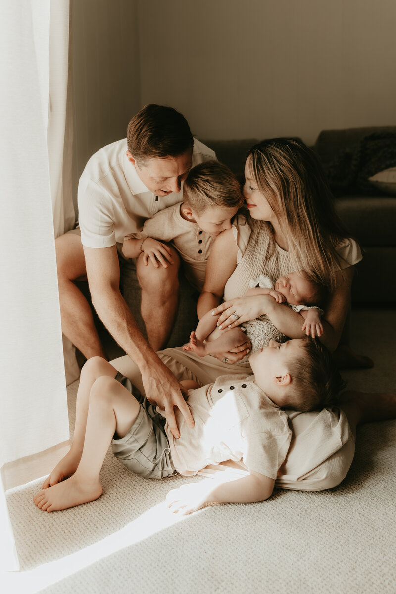 Elegant in-home newborn photography session in New Providence, New Jersey featuring parents lovingly holding their baby in soft natural light.