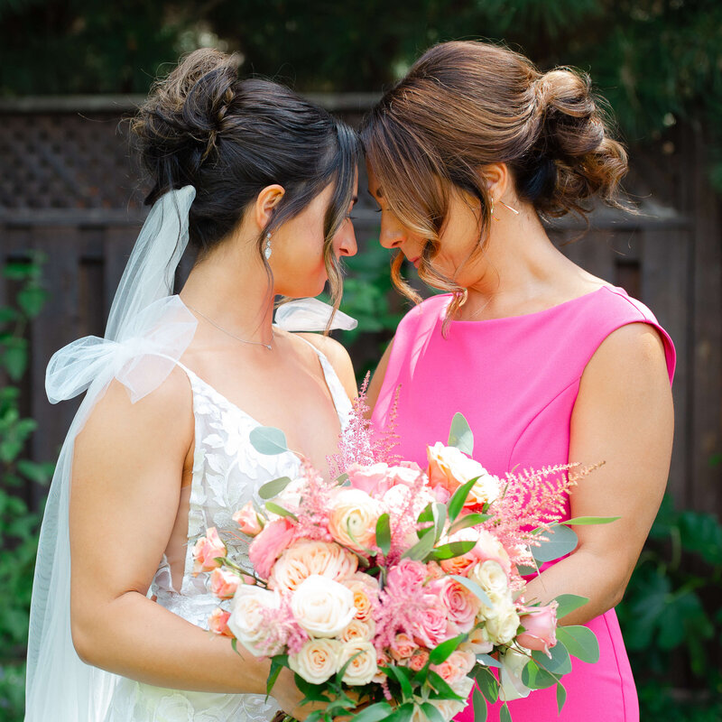 a bride and her mom in a pink dress sharing an intimate moment.  Captured by Ottawa wedding photographer JEMMAN Photographer