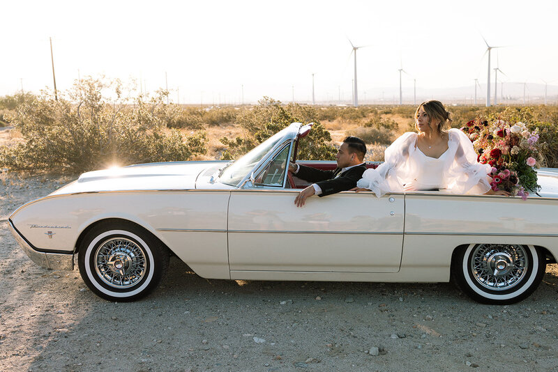 an aesthetic wedding couple  in a vintage car during their Palm Springs elopement