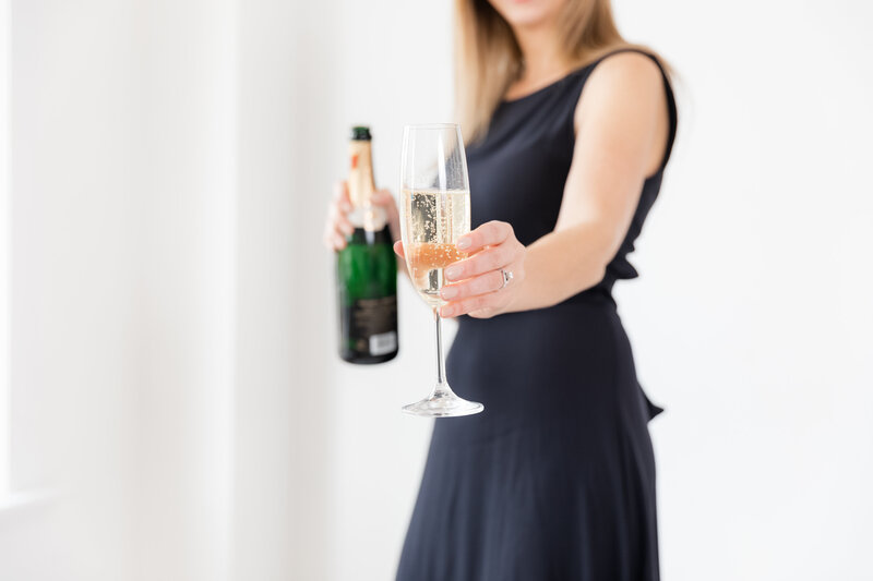 wedding planner in blue dress holding champagne glass