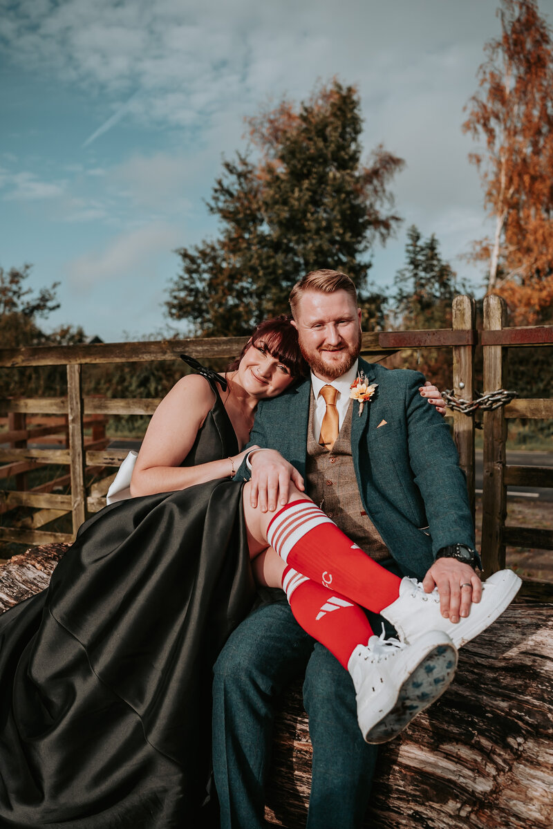 Married couple hold hands whilst walking past building smiling