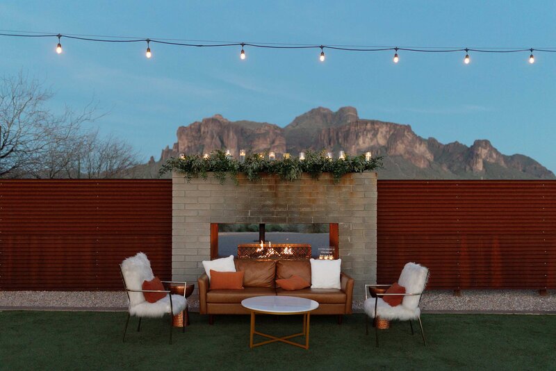 Outdoor fireplace and lounge furniture at wedding reception.
