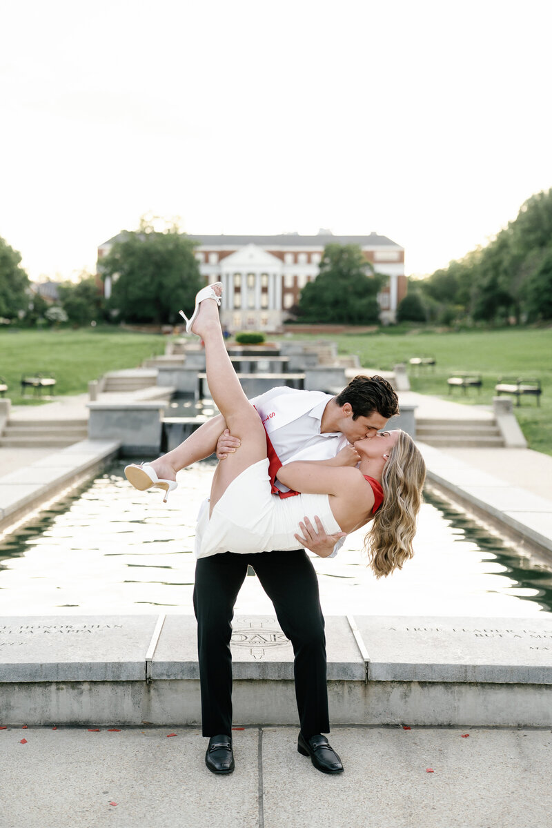 Couple celebrating their upcoming graduation sharing a kiss at the university of Maryland McKeldin Mall 