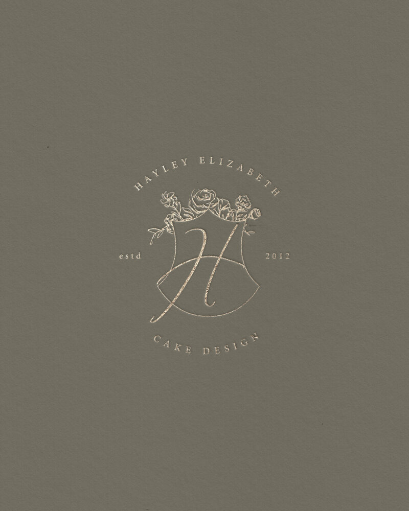 Sage green background with gold crest design — part of Hayley Elizabeth's refined brand palette