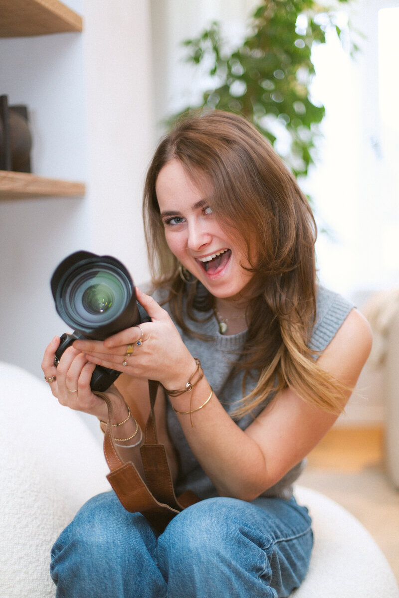 Bo Eppink, smiling while holding her digital camera, ready for her next creative shoot with model Eloise van Oranje, capturing her passion for photography and beautiful moments.