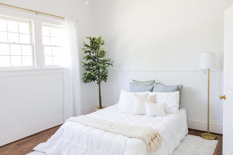 a bed made with white linens