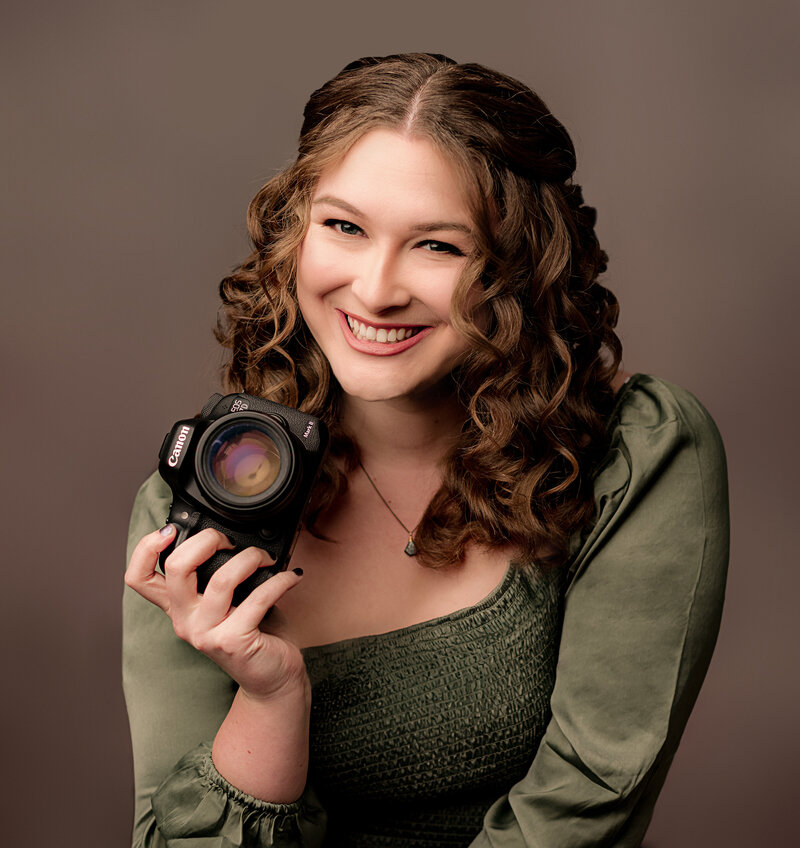 curly hair women looks at camera with back of hand on her chin