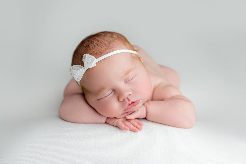 Sweet newborn baby sleeping peacefully in a cozy, warm studio setup, photographed by Victoria Lee Photography in Canton, Georgia