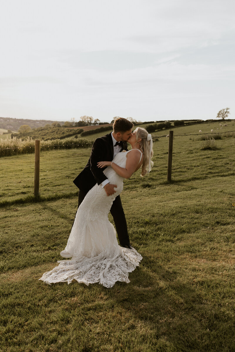 Colour cinematic shot of newly married couple sharing a joyous and tender first kiss as husband and wife at Davenport House