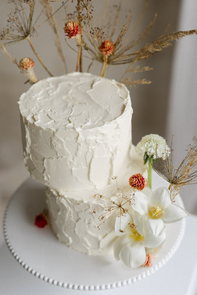 Gâteau de mariage avec fleurs blanches et oranges. 