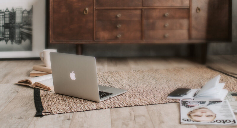 A laptop resting on a soft rug within a stylish living room environment.