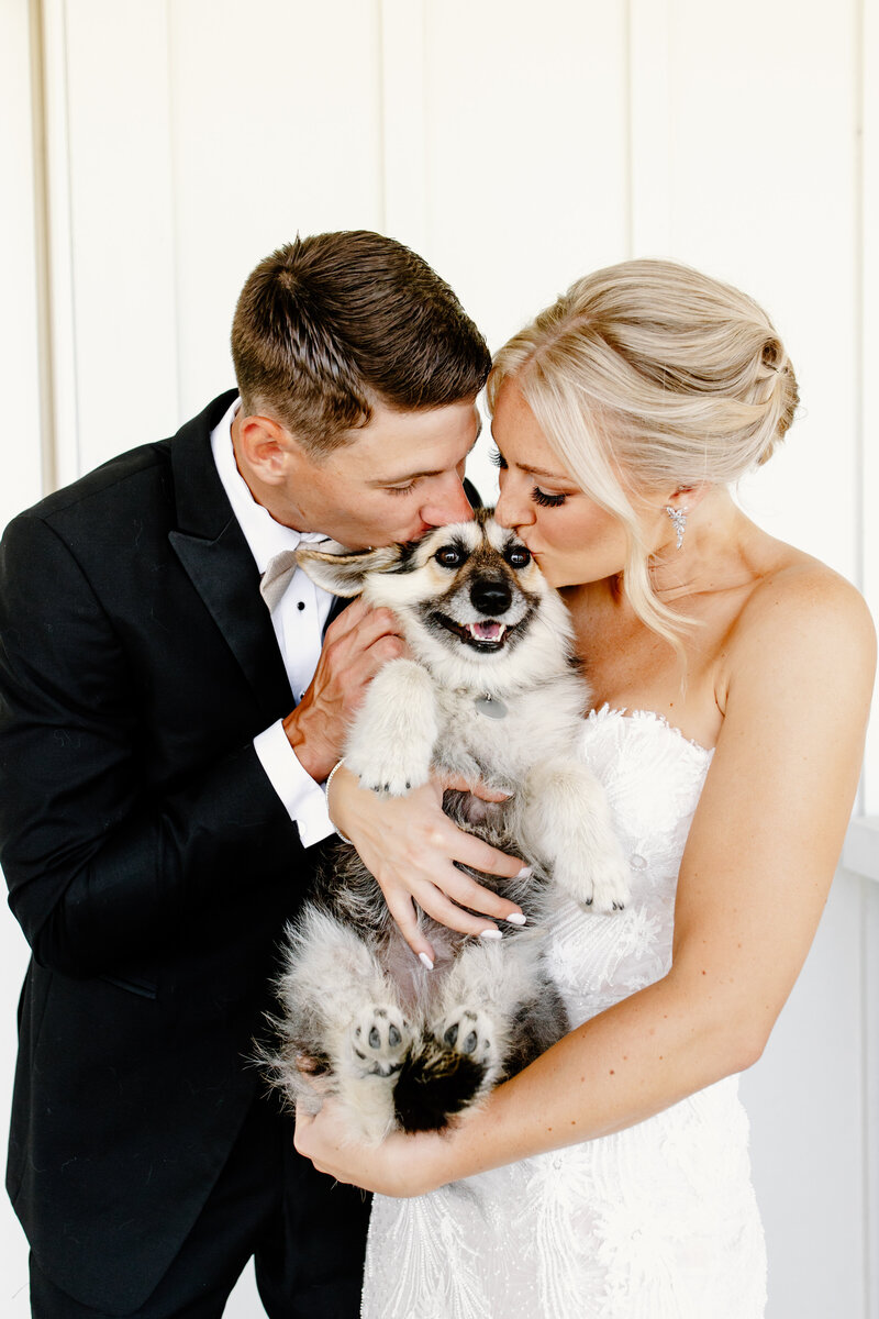Bride and groom kiss their dog