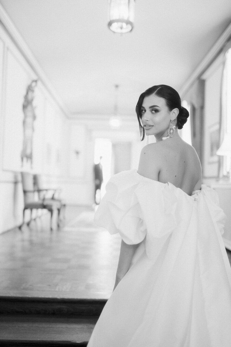 bride standing in the stairs in an off the shoulder  monique lhuillier gown