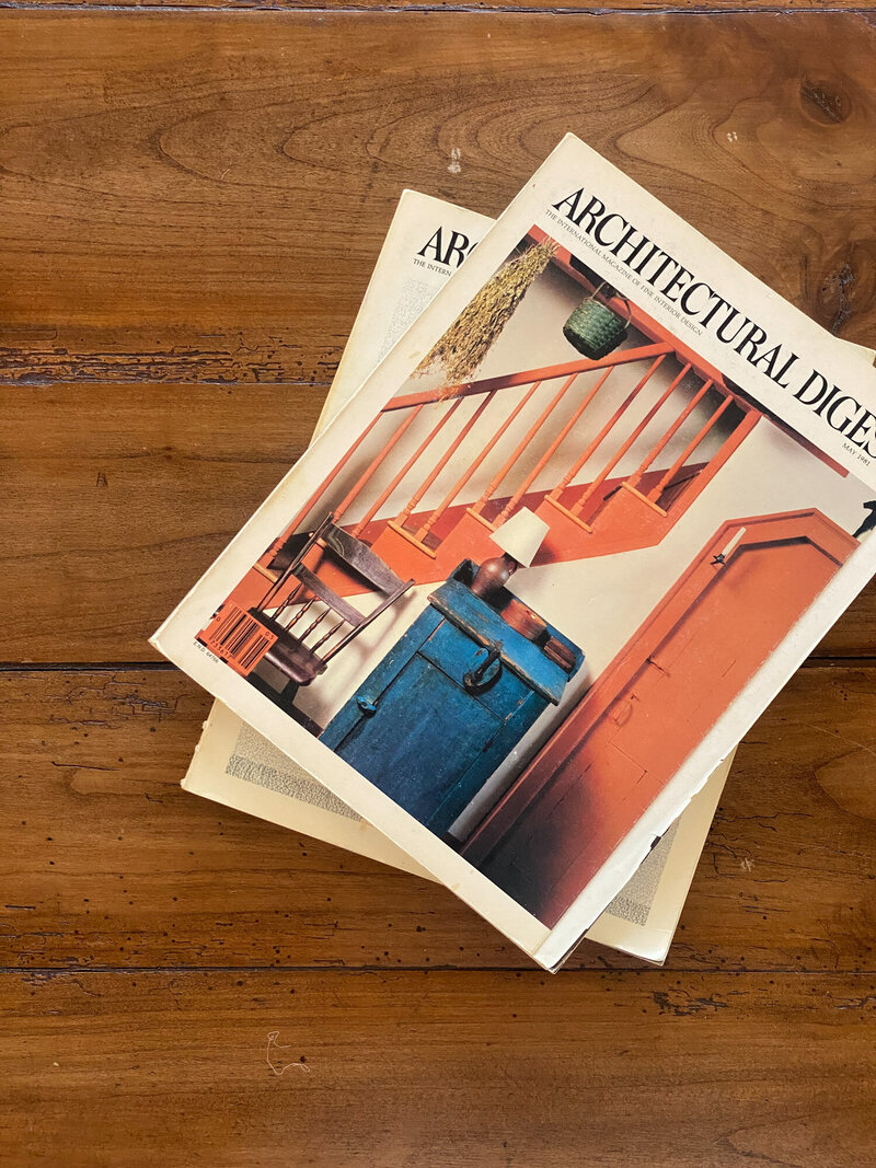 Stacked pair of Architectural Digest Magazines sitting on a wooden table