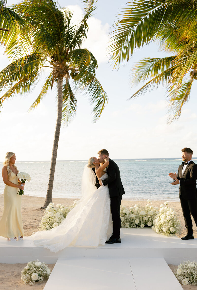Newlyweds embracing with lush tropical foliage in the background in the BVI.