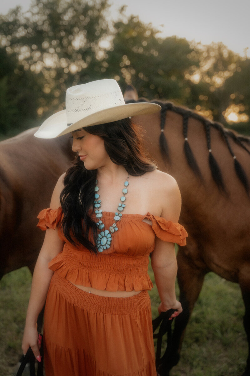 cowgirl posing with horses