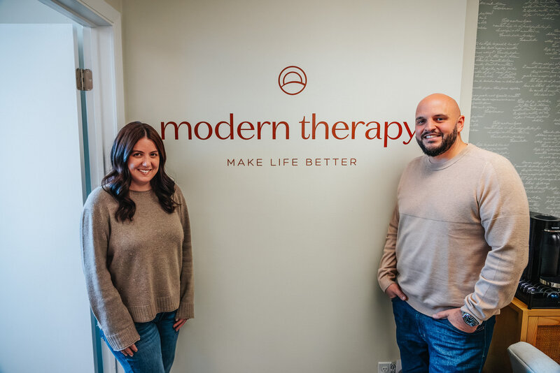 Man and woman standing in front of company logo