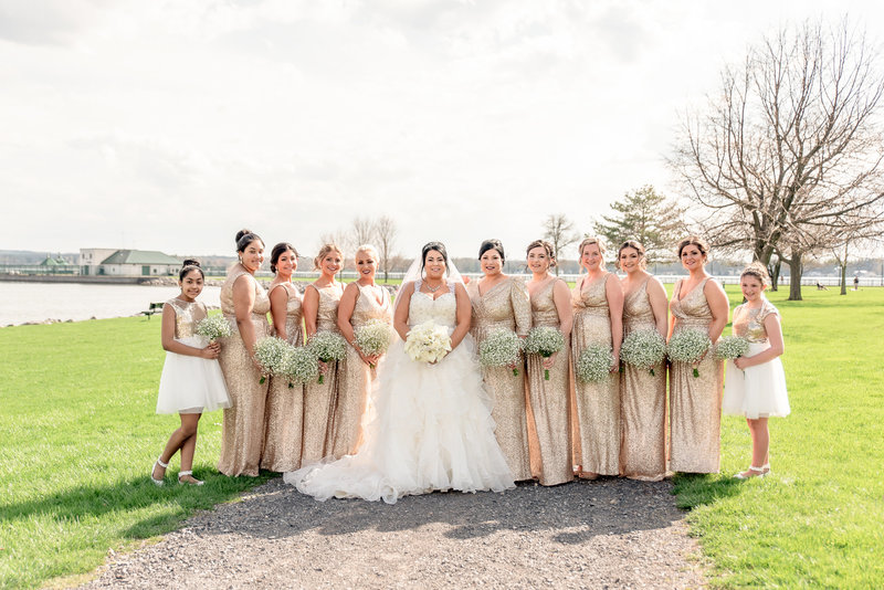 Bride poses with her bridesmaids, all dressed in gold colored dresses