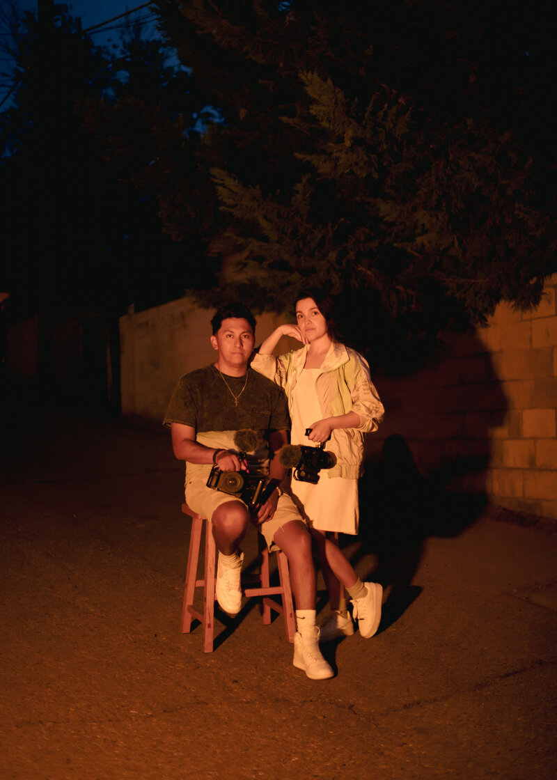couple sitting on stool and looking at the camera