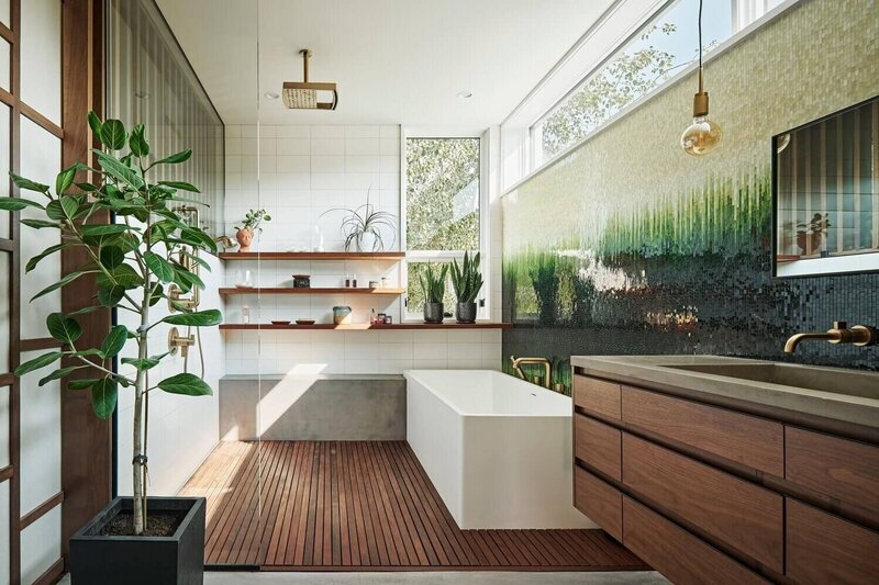 concrete bench in rain shower with floating shelves in modern home primary bathroom