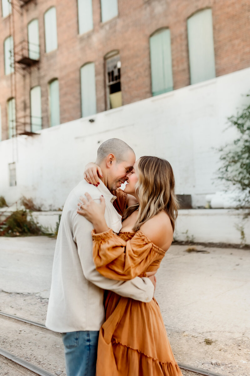 Meet your Kansas City Family Photographers Lindsey and Fabio while they playfully hug each other in urban downtown family photos shoot.