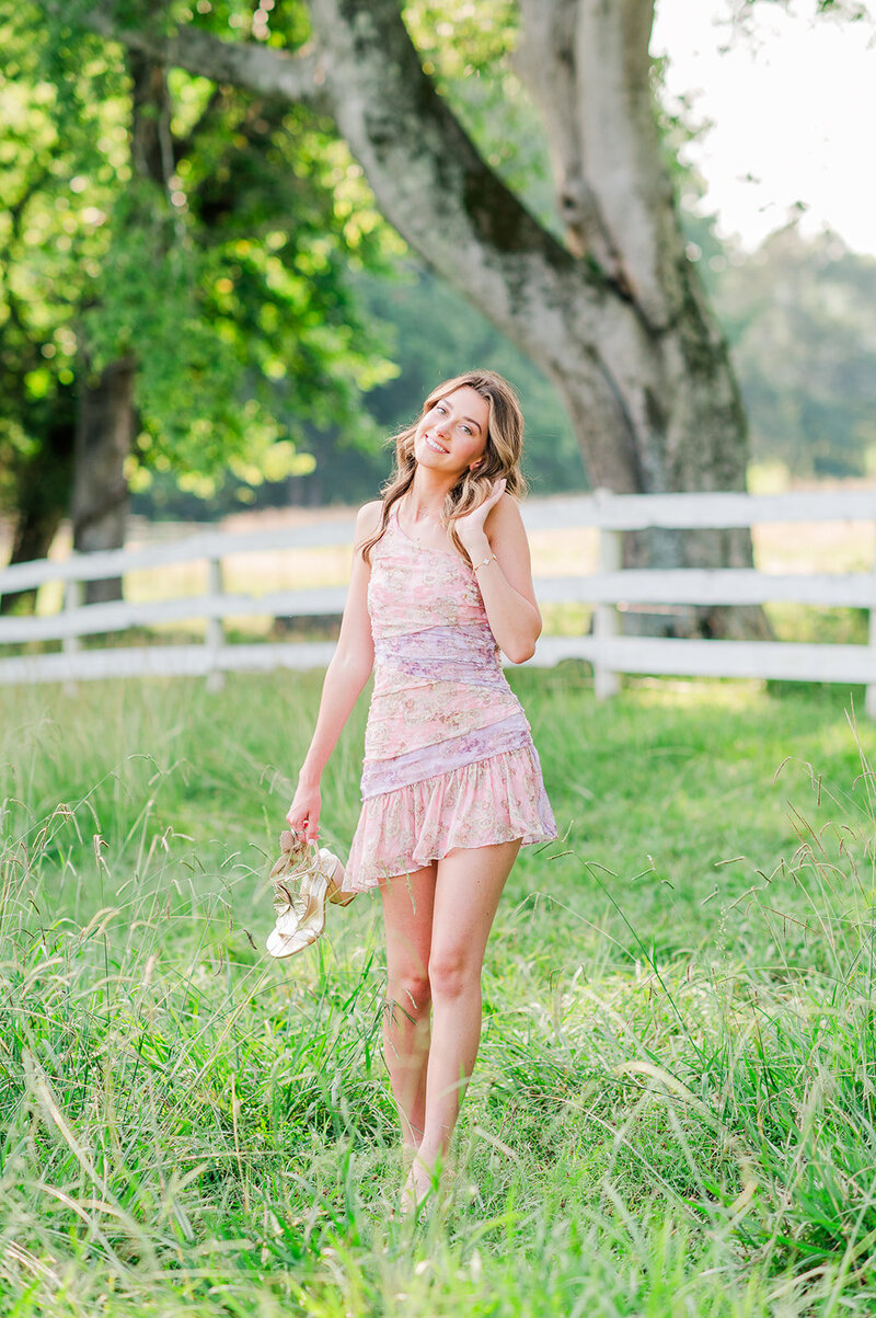 girl in a pink dress standing in a field