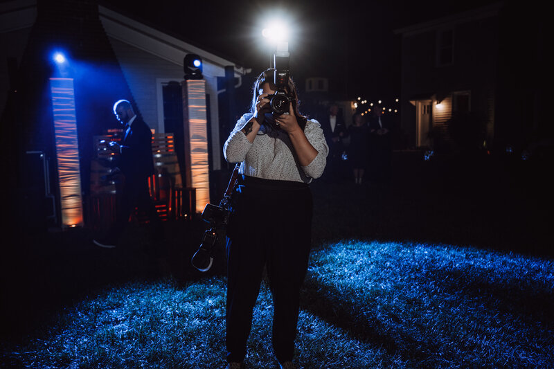 A BTS photo of Kristen Catoe photographing at a wedding.