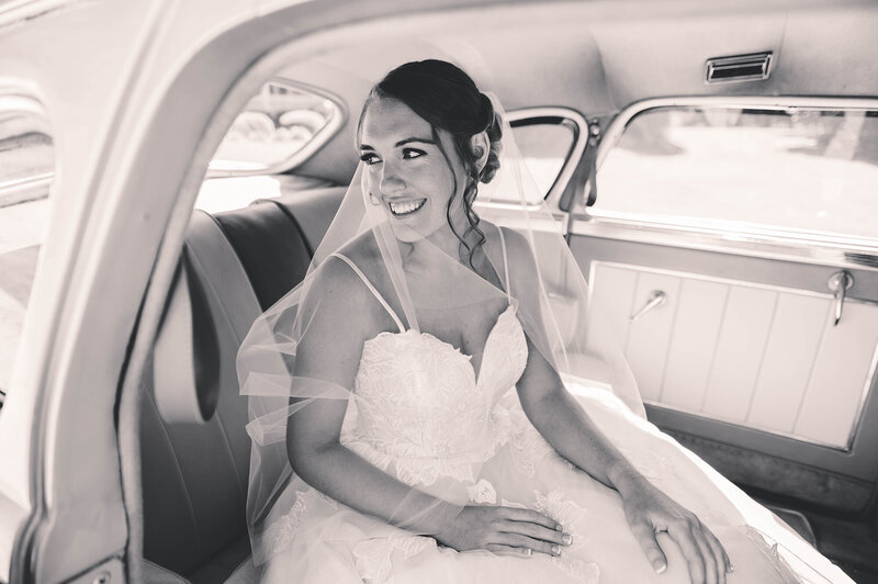 Bride peers out the window of a classic rolls royce on her Micro Wedding day in Asheville, NC.
