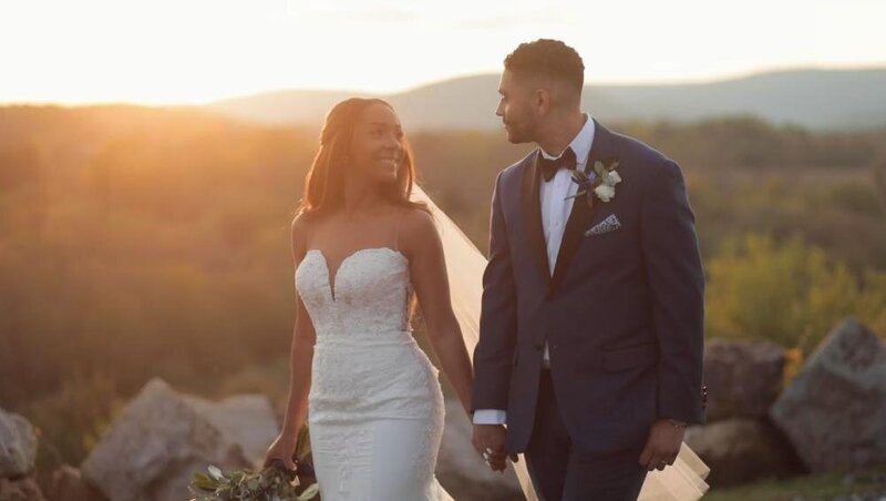Destination Wedding Photographer captures bride and groom holding hands during sunset.