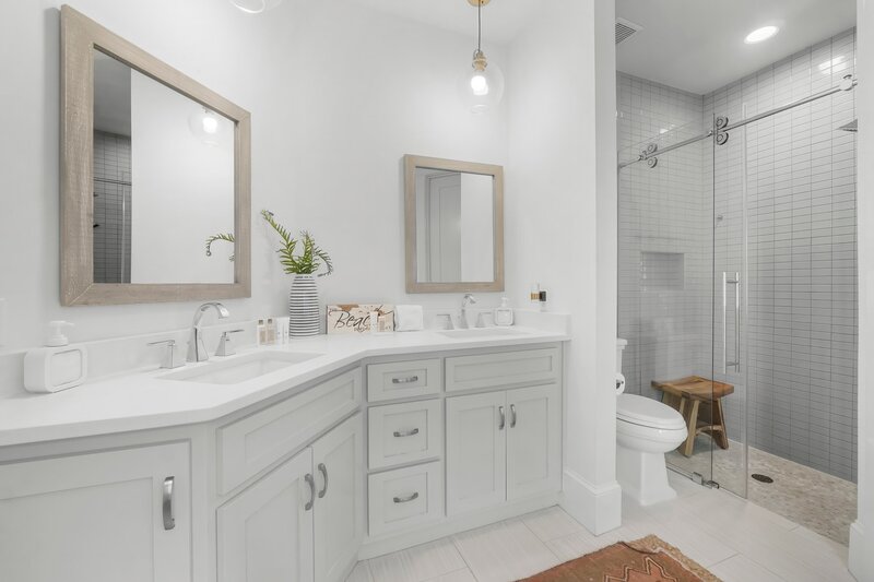 Elegant bathroom with dual vanities, tiled walk-in shower, and coastal decor in this Santa Rosa Beach rental.
