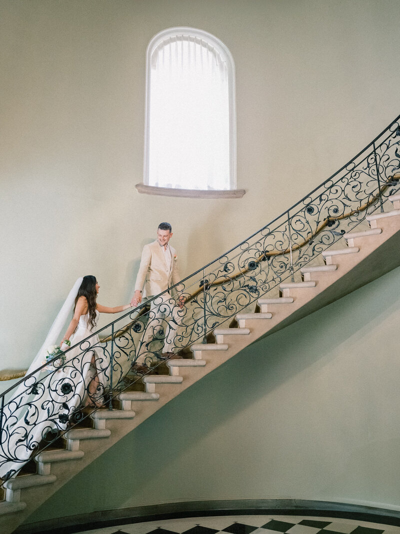 bride and groom walking up the stairs
