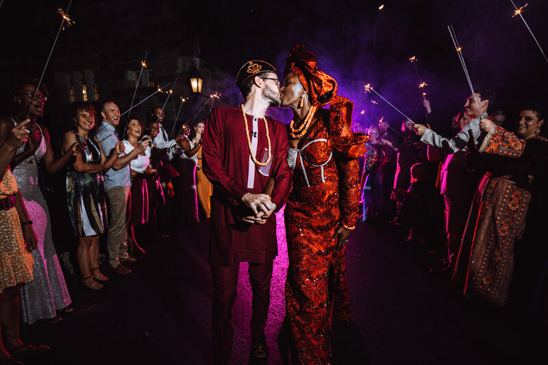 A bride and groom kiss as they make their exit from their Nigerian-American fusion wedding