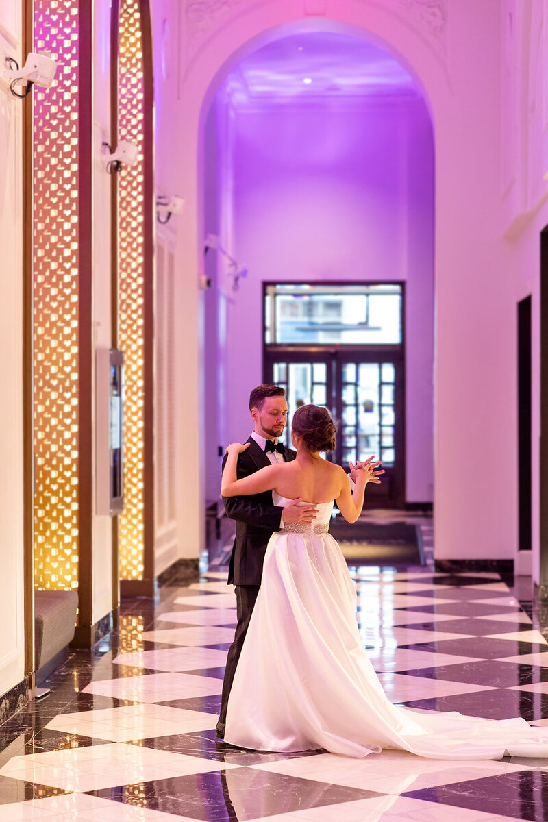 The elegant bride and classy groom dance to their own music in the luxurious lobby of Hotel Washington in Washington DC