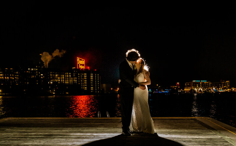 Kissing bride and groom, Domino Sugar sign in background at night time, Baltimore Wedding Photography