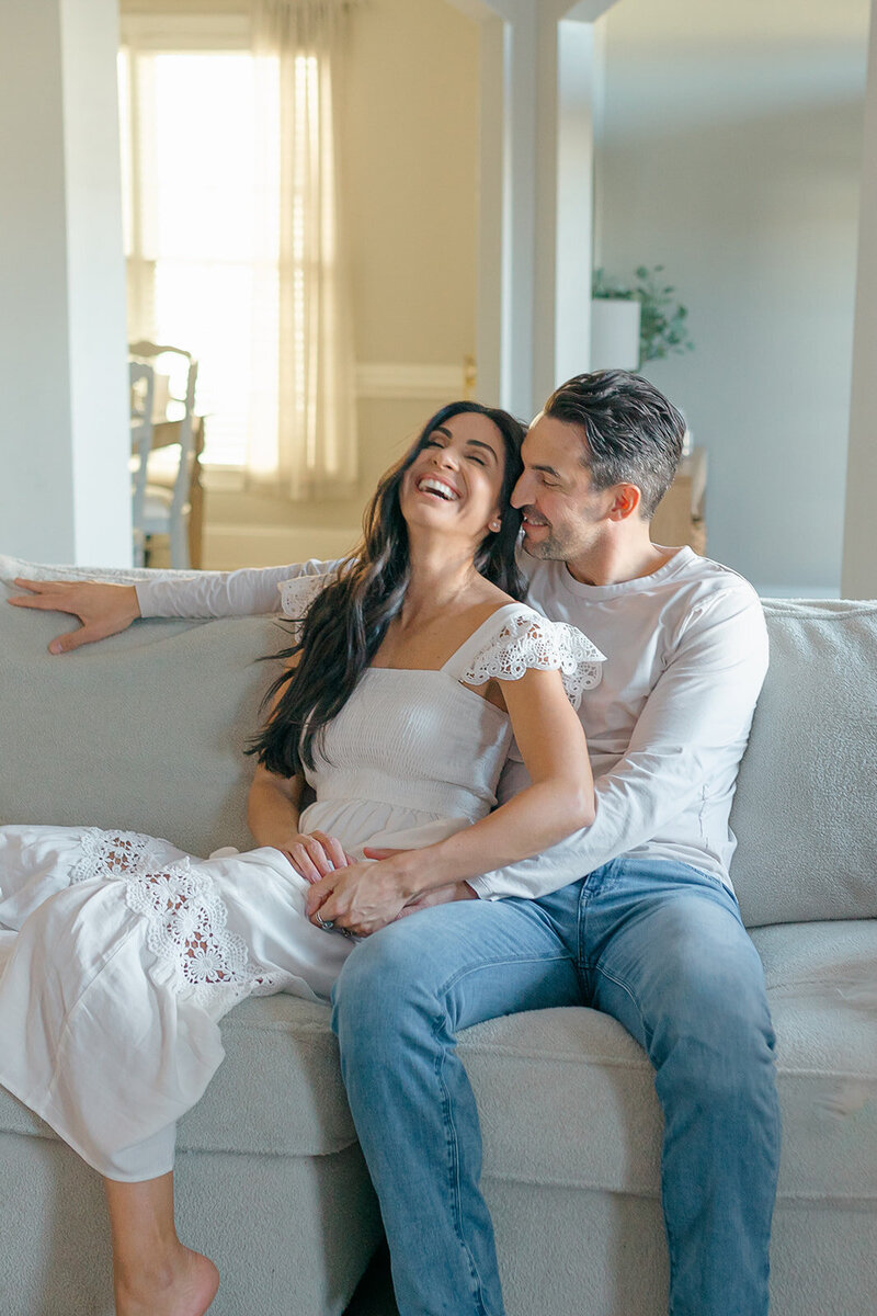 Husband and wife snuggling on couch