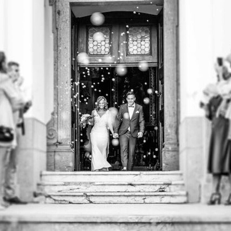 A bride and groom leave their wedding celebration.