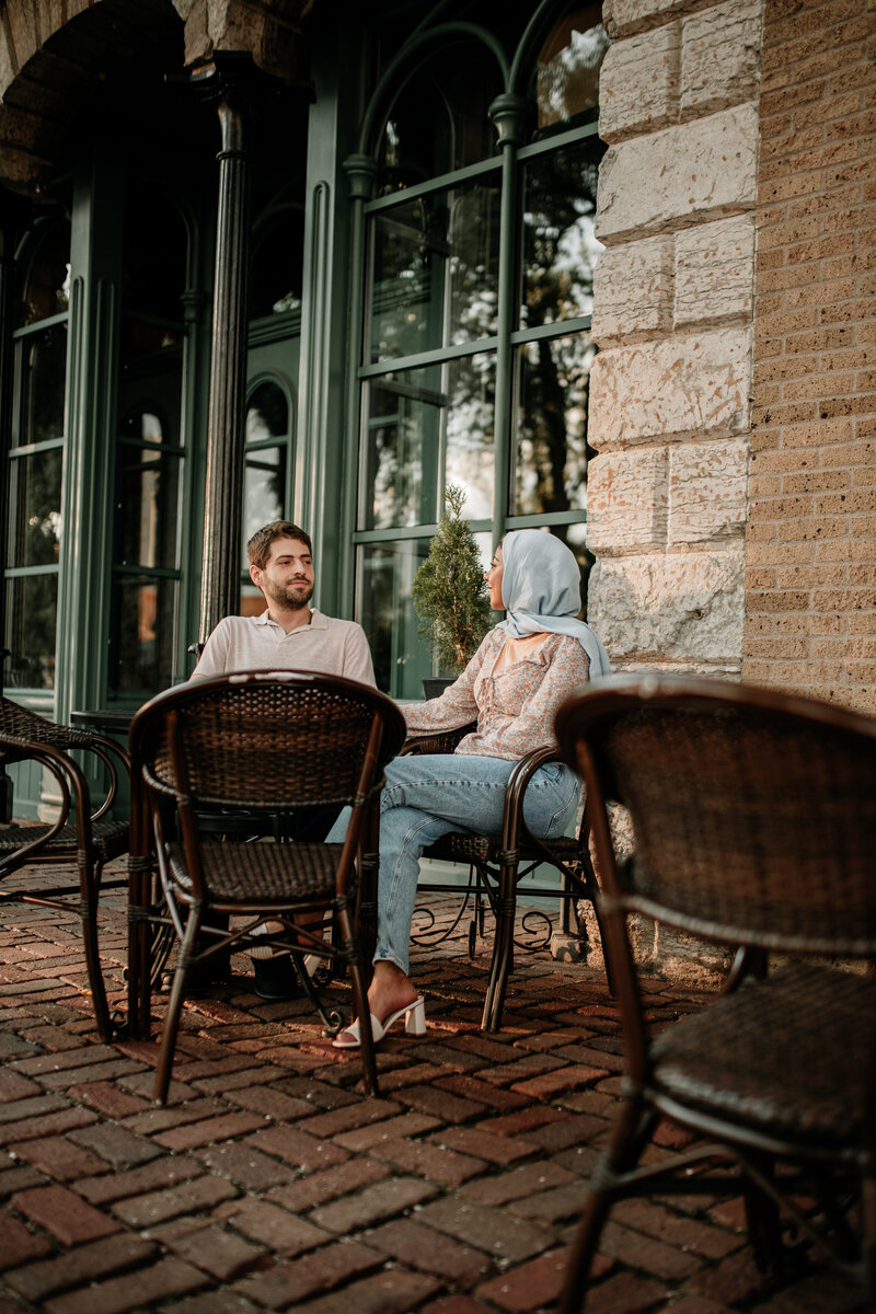 Downtown Minneapolis couple sits outside of a café during their engagement session.