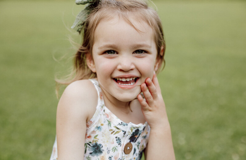 Headshot of a girl smiling at the camera. 