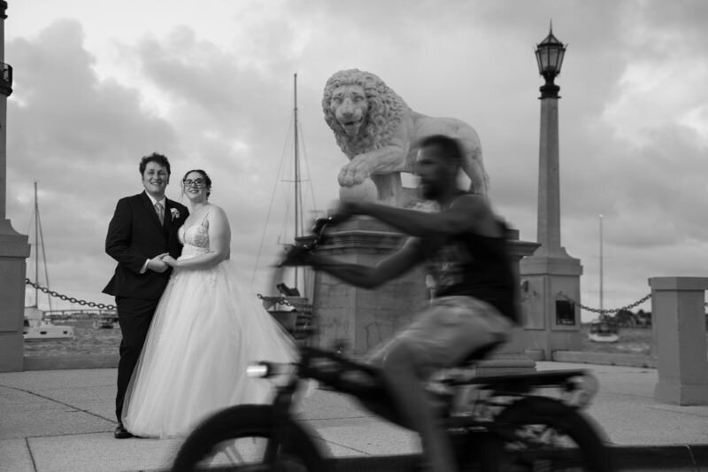 black and white picture of bride and groom in front of the lions near the bridge of lions in st augustine florida