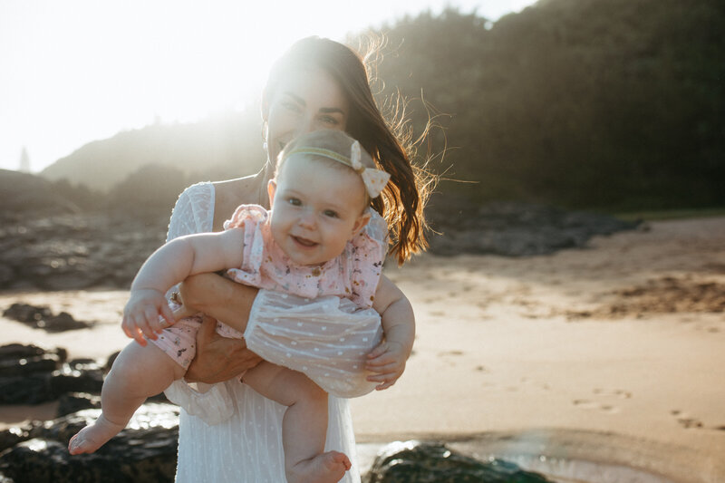 Family Photographer  and  Candid Family  Photos on the Beach by Natural Light Phootgrapher Rebecca Rottcher. Mother and  baby photo on the beach