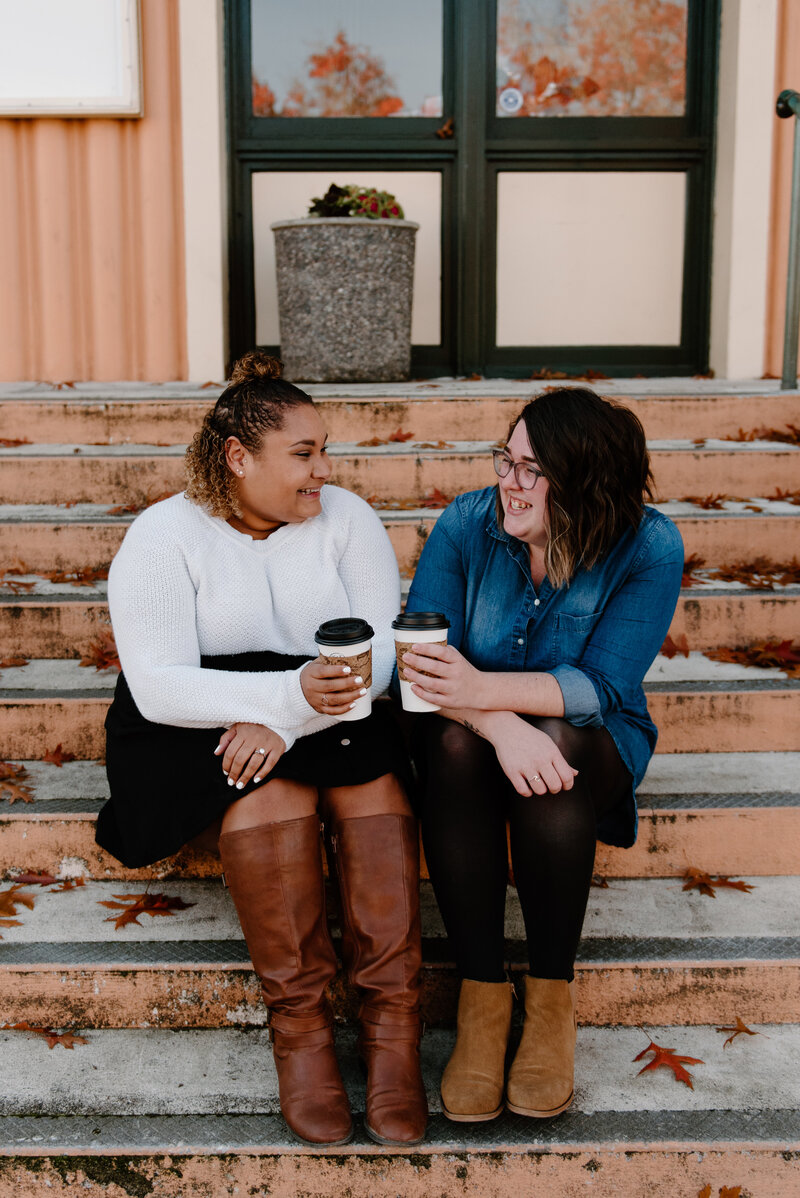 Ashley and Katelin sitting on the stairs drinking coffee.